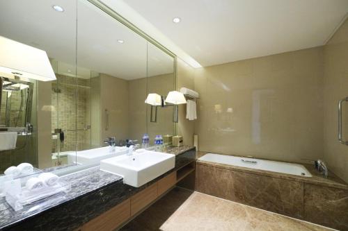 a bathroom with a sink and a bath tub and a sink at Crowne Plaza Shanghai Anting-Auto City - 15 Minutes drive to F1 in Jiading