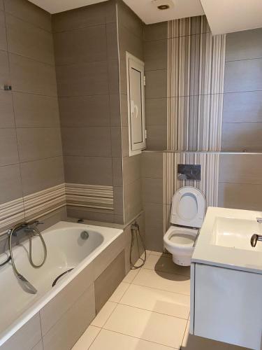 a bathroom with a tub and a toilet and a sink at Mahdia Palace in Hiboun