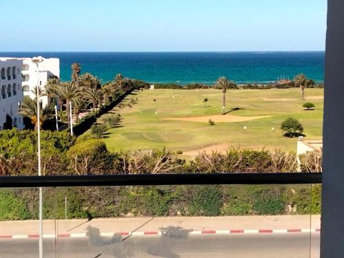 a view of a golf course with the ocean at Mahdia Palace in Hiboun