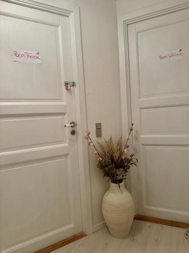 a vase with flowers sitting in front of two doors at Villa Malena in Fensmark