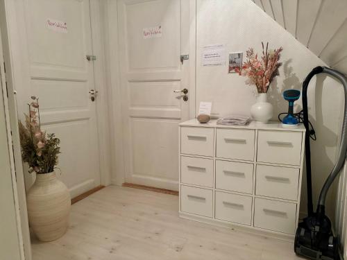 a room with two white doors and a dresser with flowers at Villa Malena in Fensmark