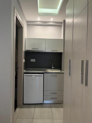 a kitchen with white cabinets and a sink at Il Mondo City Center in Stavros