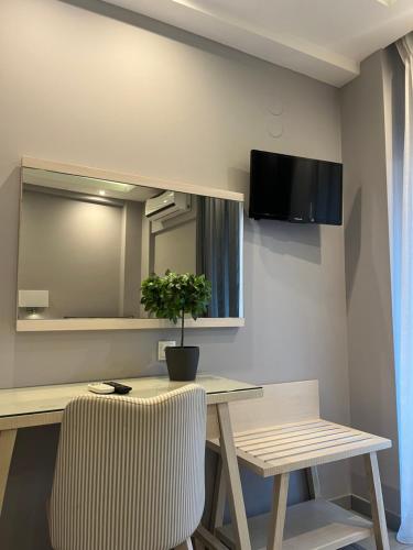 a table with a potted plant and a mirror on a wall at Il Mondo City Center in Stavros