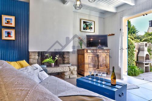un salon avec un canapé et une télévision dans l'établissement LocaLise - M20B - Ocean Lodge - Maison avec jardin clos - terrasse - plage à 400m - wifi inclus - draps inclus - animaux bienvenus, au Guilvinec