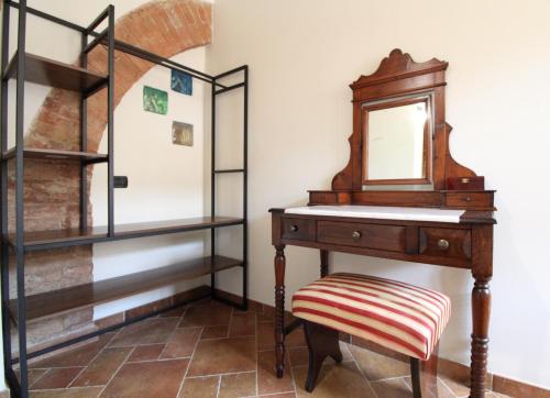 a dressing table with a mirror and a stool at The Rose in Colle Malamerenda