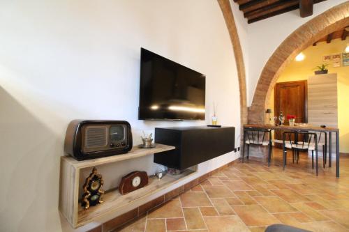 a living room with a tv on a wall at The Rose in Colle Malamerenda