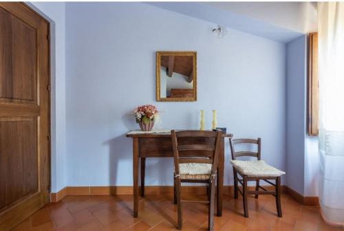 a dining room table with two chairs and a mirror at Borgo Medioevale Siete Fuentes in Santu Lussurgiu