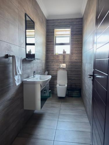 a bathroom with a sink and a toilet at Escapade Lux Guesthouse in Gaborone