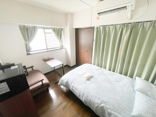 a small bedroom with a bed and a window at パルム天神西 in Susakiuramachi