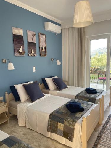 two beds in a room with blue walls at ILEKTRA Apartments Blue & Red in Plataria
