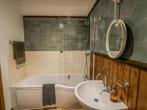 a bathroom with a tub and a sink and a mirror at Talbot Lodge in Stafford
