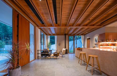a kitchen with wooden ceilings and a bar with stools at Shanyu Life Huangshan Design Hotel in Huangshan