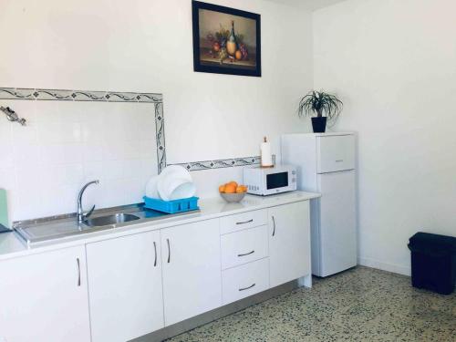 una cocina con fregadero y refrigerador en Paderne Village House, en Paderne