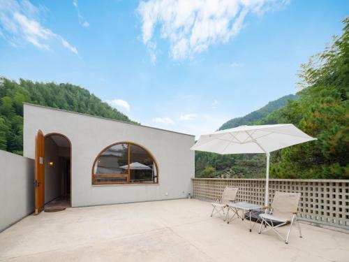 a patio with two chairs and an umbrella at Shanyu Life Huangshan Design Hotel in Huangshan