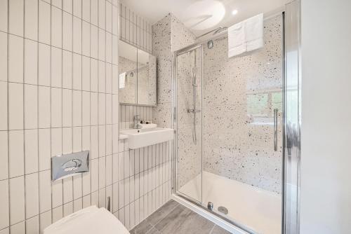a bathroom with a shower and a toilet and a sink at Roomspace Serviced Apartments -Oasis Way in London