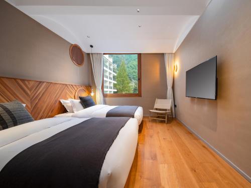 a hotel room with two beds and a flat screen tv at Shanyu Life Huangshan Design Hotel in Huangshan