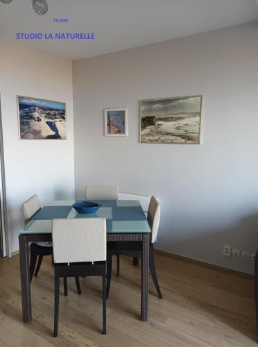 une salle à manger avec une table et des chaises bleues dans l'établissement RESIDENCE LA NATURELLE Studio, à Wimereux