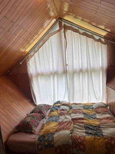 a bed in a small room with a window at The Sound Of Silence Homestay Đà Lạt in Da Lat