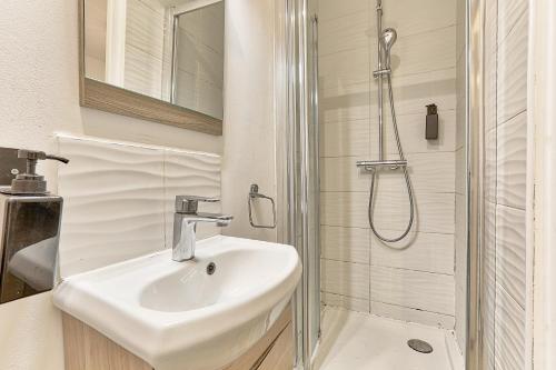 une salle de bain avec un lavabo et une douche dans l'établissement 10 minutes à pied de La Villette - 4 voyageurs, à Paris