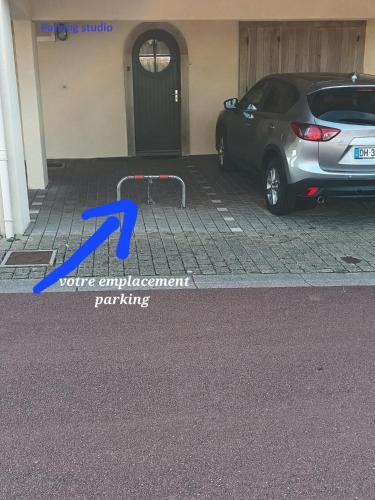 a car parked in a parking lot with a blue arrow at RESIDENCE LA NATURELLE Studio in Wimereux