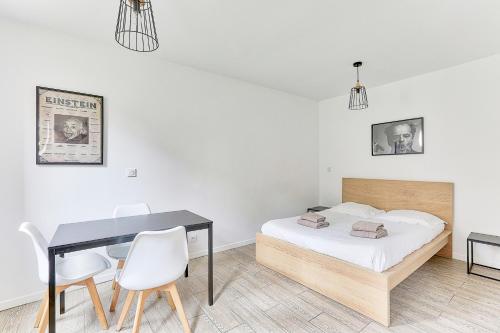 une chambre avec un lit, une table et des chaises dans l'établissement 10 minutes à pied de La Villette - 4 voyageurs, à Paris