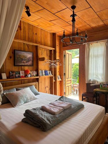 a large bed in a room with wooden walls at The Sound Of Silence Homestay Đà Lạt in Da Lat