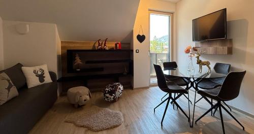 a living room with a table and a piano at Vila Mojca SKI IN&OUT - Apartmaji Lena in Kranjska Gora