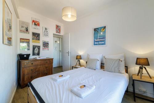une chambre avec un grand lit blanc avec deux serviettes dessus dans l'établissement Joli appartement à côté du Palais des Festivals, à Cannes