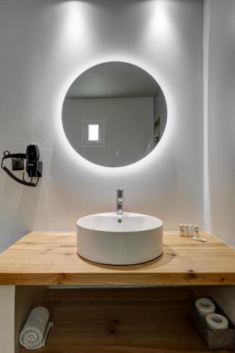 a bathroom with a white sink and a mirror at Aegean Paradiso Vacation Club - "Adults Only" in Azolimnos
