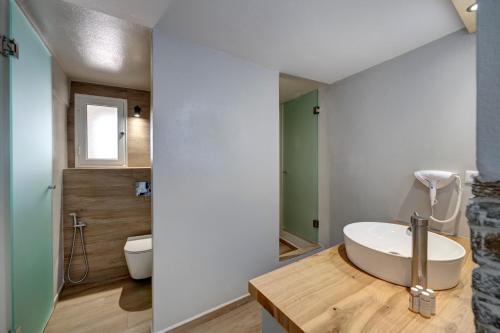 a bathroom with a white sink and a toilet at Aegean Paradiso Vacation Club - "Adults Only" in Azolimnos
