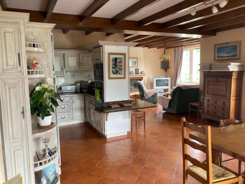 d'une cuisine et d'un salon avec des placards blancs et une table. dans l'établissement Gîte avec spa et piscine près de Millau, à Compeyre