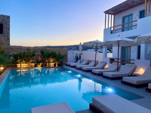 a villa with a swimming pool at dusk at Mykonos Dot Suites in Ano Mera