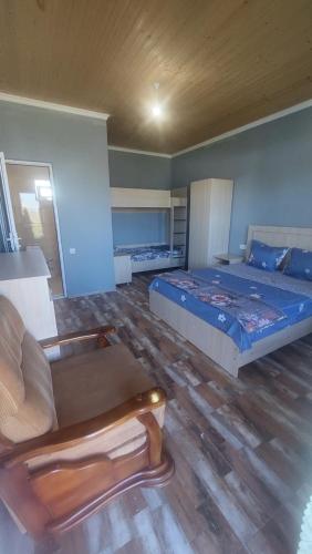 a bedroom with a bed and a couch and a chair at Отдых на море in Grigoleti