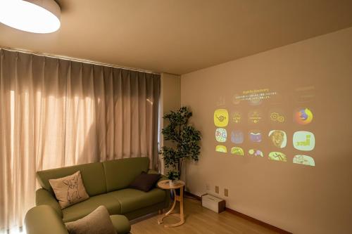 a living room with a green couch in front of a window at Spacious Living and Garden 10 min walk from Shizuoka station in Shizuoka