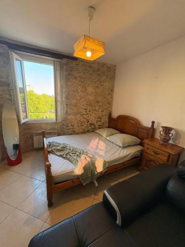 une chambre avec un lit et une fenêtre dans l'établissement Au pied de l'ermitage, à Alès