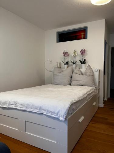 a bedroom with a white bed with flowers on it at NO-Television One bedroom apartment in Herrsching am Ammersee
