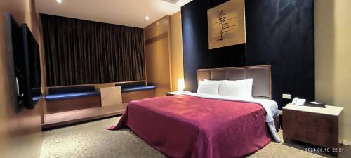 a hotel room with a bed and a television at Shantis Motel in Chiayi City