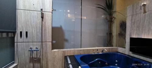 a bathroom with a blue tub and a mirror at Shantis Motel in Chiayi City