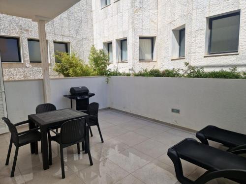 un patio avec une table et des chaises et un bâtiment dans l'établissement Playa Son Moll, à Cala Ratjada