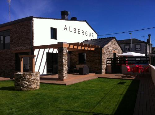 a brick house with a sign that reads alberge at Albergue Oasis in Sarria
