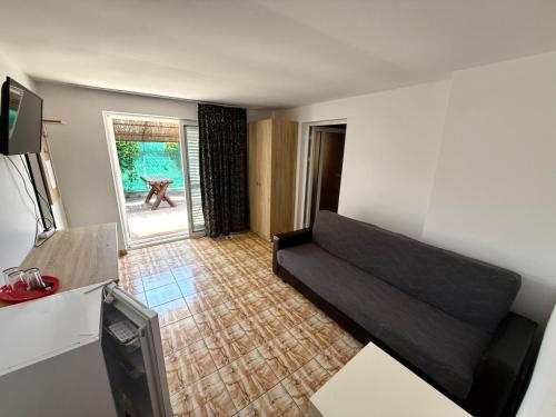 a living room with a black couch in a room at Hotel Decebal Eforie Nord in Eforie Nord