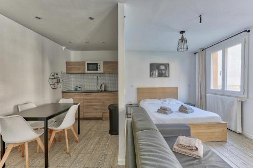 une chambre avec un lit, une table et un canapé dans l'établissement Séjour près du Parc des Buttes-Chaumont, à Paris