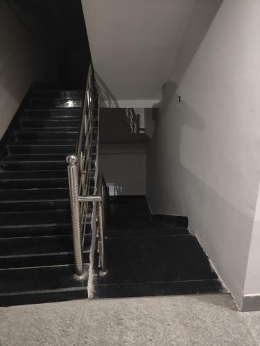 a staircase in a building with a metal railing at Mahadev Hotel And Restaurant in Rudraprayāg