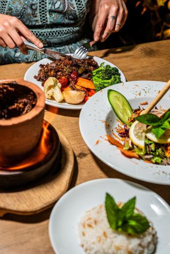 a table with plates of food and a person eating at HMA Hotel & Suites in Alanya