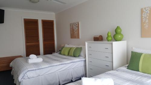 um quarto com 2 camas e uma cómoda em Villa Riviera on River Front em Ballina