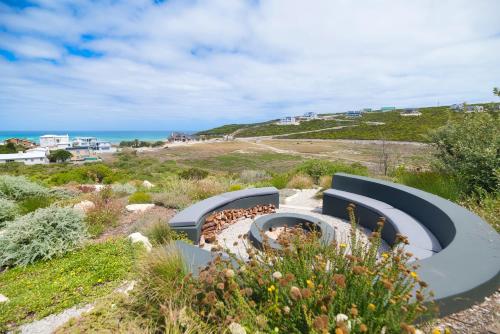 a fire pit with a view of the ocean at Fynbos Hill Luxury Accommodation in Agulhas