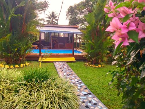 a garden with a house with a pool and plants at Ocean Breeze Villa in Savusavu