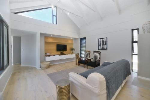 a living room with a couch and a tv at Fynbos Hill Luxury Accommodation in Agulhas