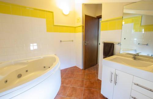 a bathroom with a tub and a sink at Porto Antigo 1 - Three Bedroom, Pool & Wifi in Santa Maria