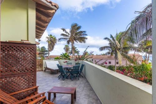 a balcony with a table and chairs and palm trees at Porto Antigo 1 - Three Bedroom, Pool & Wifi in Santa Maria
